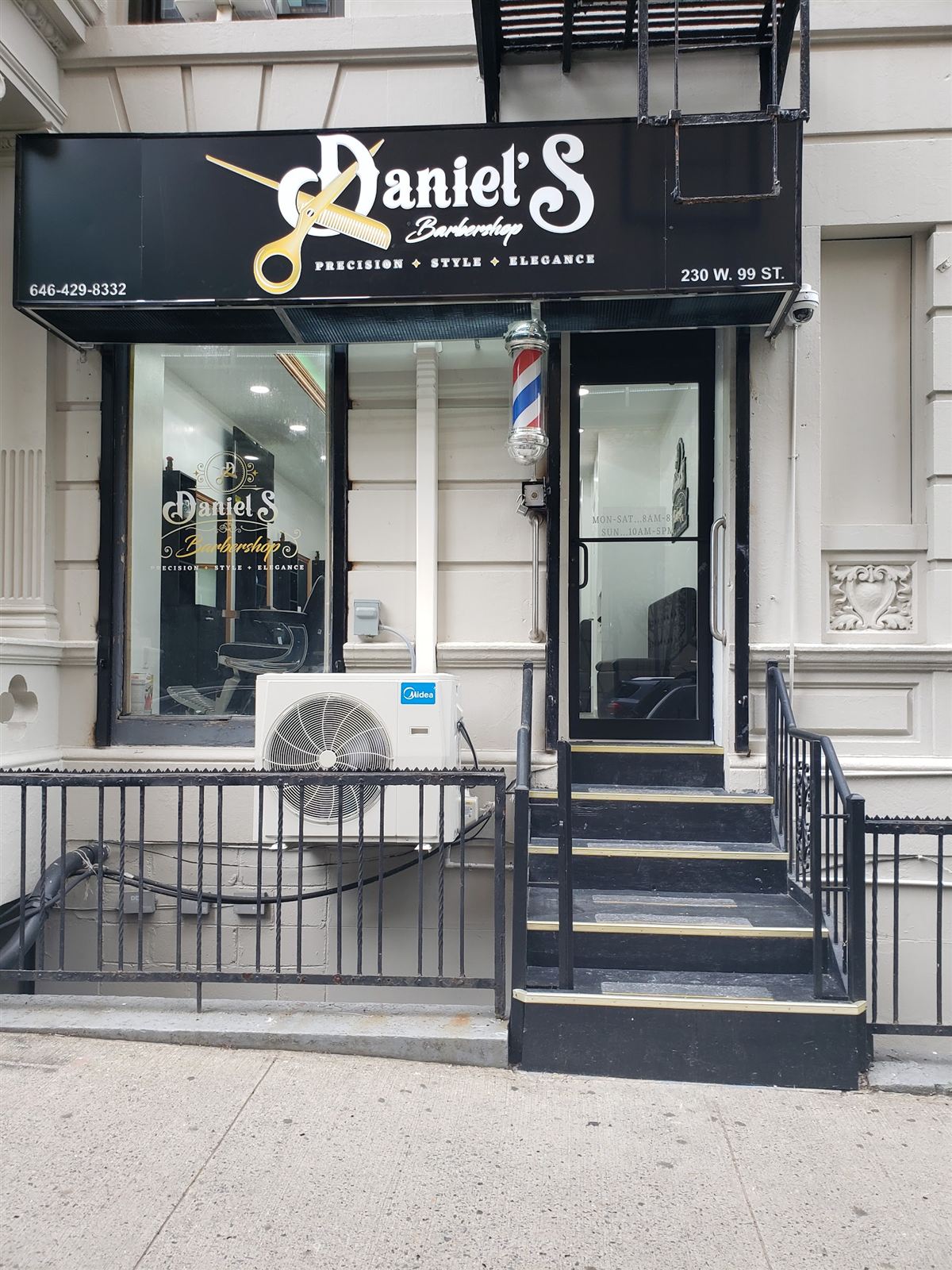Daniel's Barbershop storefront on West 99th Street, with a black sign, barber pole lamps and steps up to the door